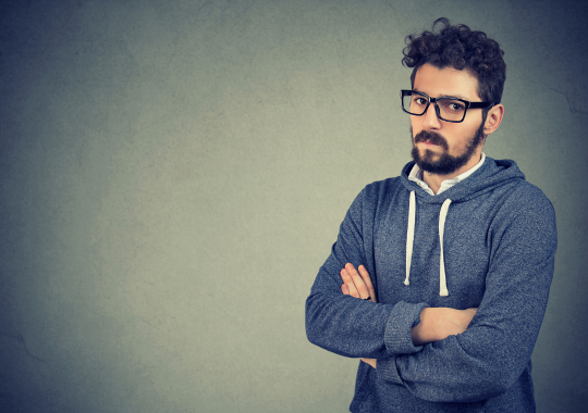 איש נעלב עם קפוצ'ון אפור ומשקפיים שחורות