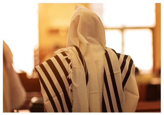 אדם לבוש טלית מתפלל בבית הכנסת